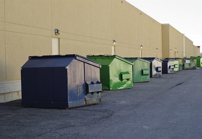 a row of blue construction dumpsters on a job site in Bradford